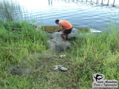 Homem retirando o material ilegal do barco (Foto Divulgação: Policia Ambiental)